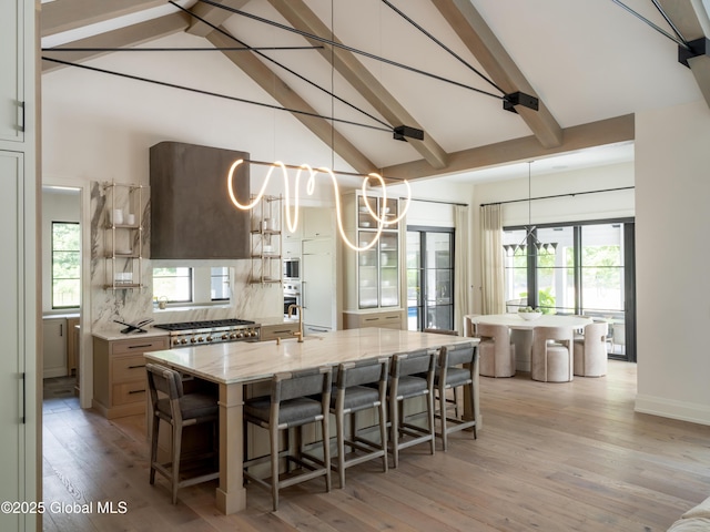 kitchen with a large island, hanging light fixtures, and a breakfast bar area