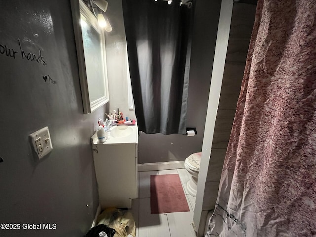 bathroom featuring toilet, tile patterned floors, and vanity