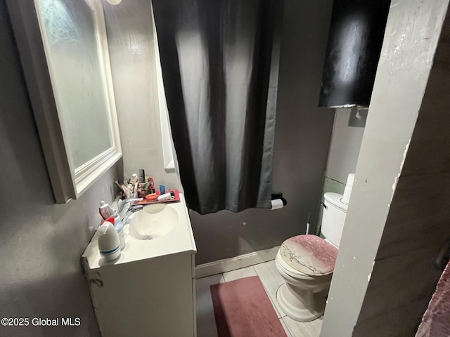 bathroom featuring toilet, vanity, and tile patterned flooring