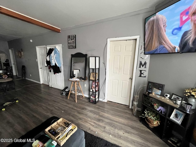 living room featuring dark wood-type flooring and beam ceiling