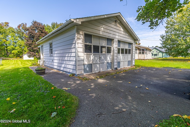 view of side of property with a yard, a garage, and an outdoor structure