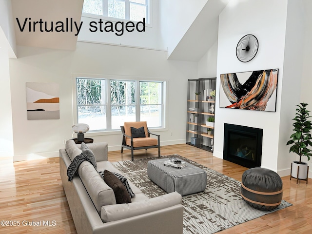 living room featuring a towering ceiling and hardwood / wood-style floors