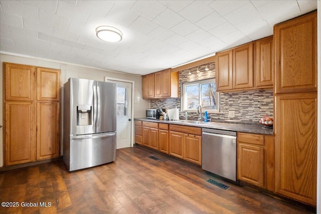 kitchen with dark hardwood / wood-style flooring, stainless steel appliances, sink, backsplash, and ornamental molding