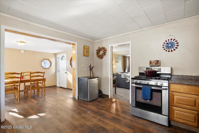 kitchen featuring appliances with stainless steel finishes, crown molding, and dark hardwood / wood-style flooring