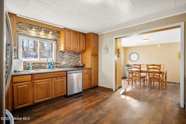 kitchen featuring dark wood-type flooring, sink, stainless steel appliances, and tasteful backsplash