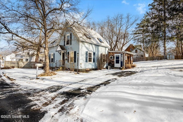 view of snow covered exterior with a shed