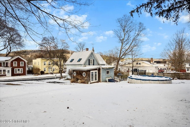 snow covered house with a covered pool