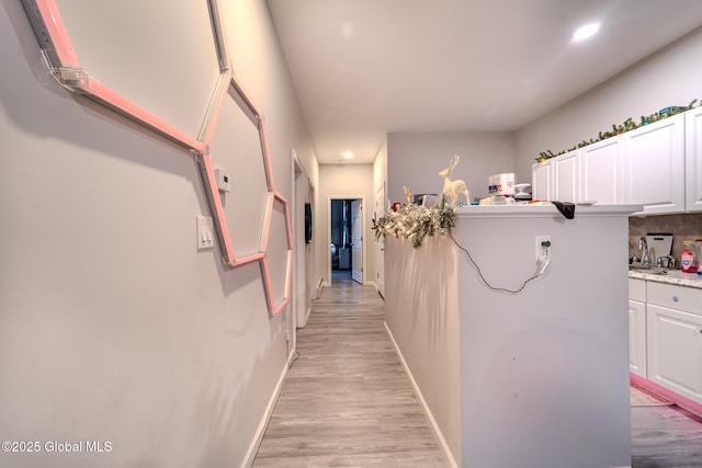 hallway featuring sink and light wood-type flooring