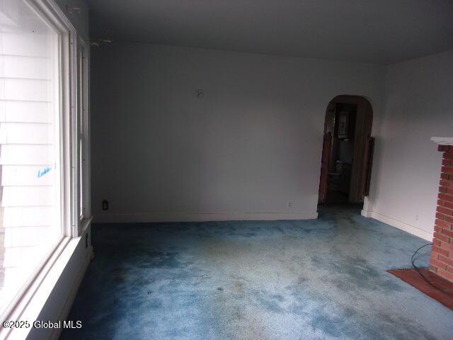 carpeted spare room featuring a fireplace