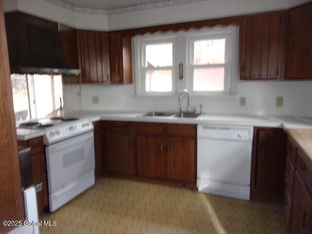 kitchen with sink, white appliances, and wall chimney exhaust hood