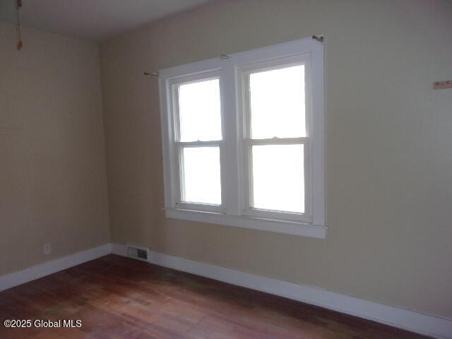 unfurnished room with dark wood-type flooring