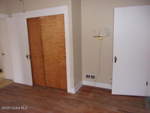 interior space with a closet and dark hardwood / wood-style floors