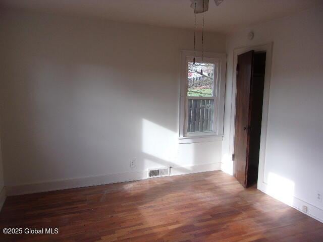 unfurnished dining area with dark wood-type flooring