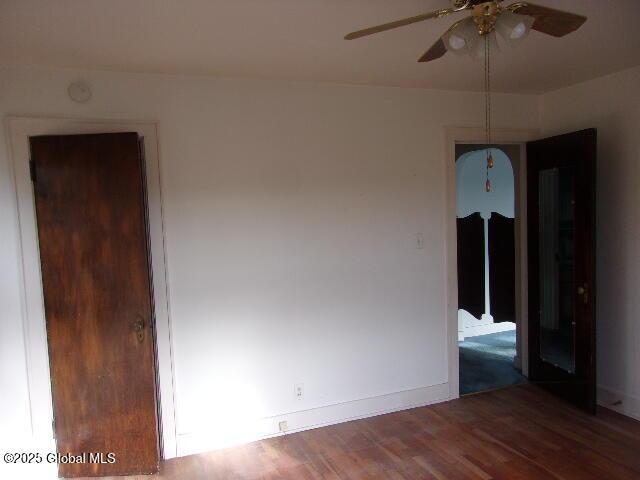 spare room with ceiling fan and wood-type flooring