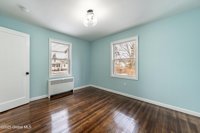 unfurnished room with radiator and dark hardwood / wood-style flooring