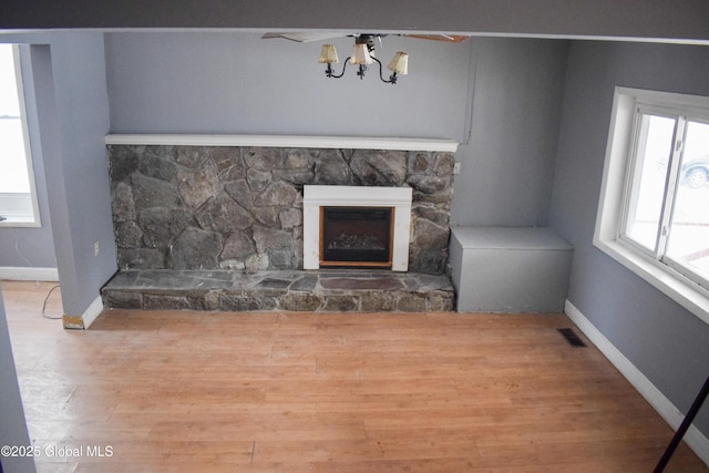 unfurnished living room with a chandelier, a fireplace, and hardwood / wood-style floors