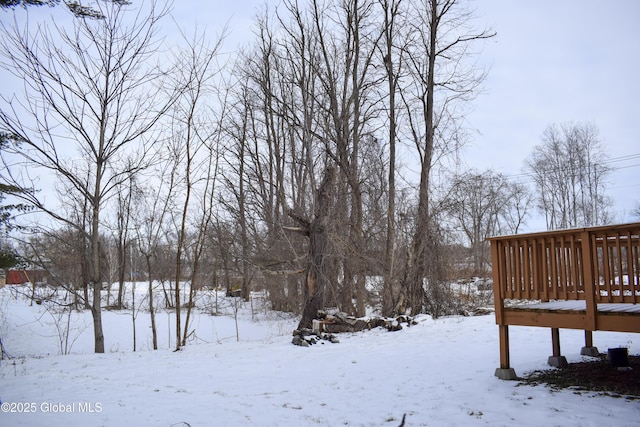 snowy yard featuring a wooden deck