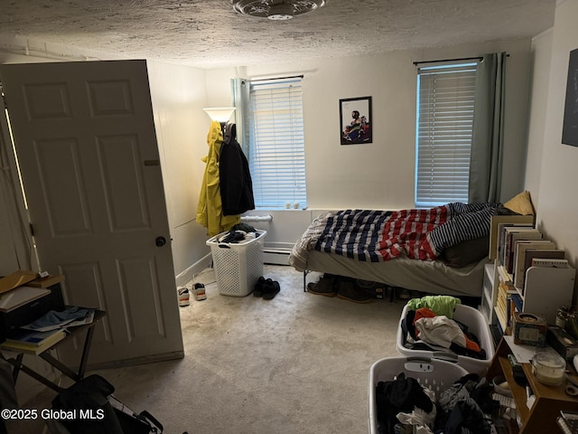 carpeted bedroom featuring a textured ceiling and a baseboard heating unit