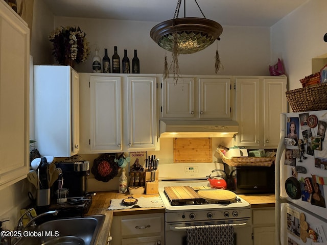 kitchen with white cabinetry, custom exhaust hood, white appliances, hanging light fixtures, and sink