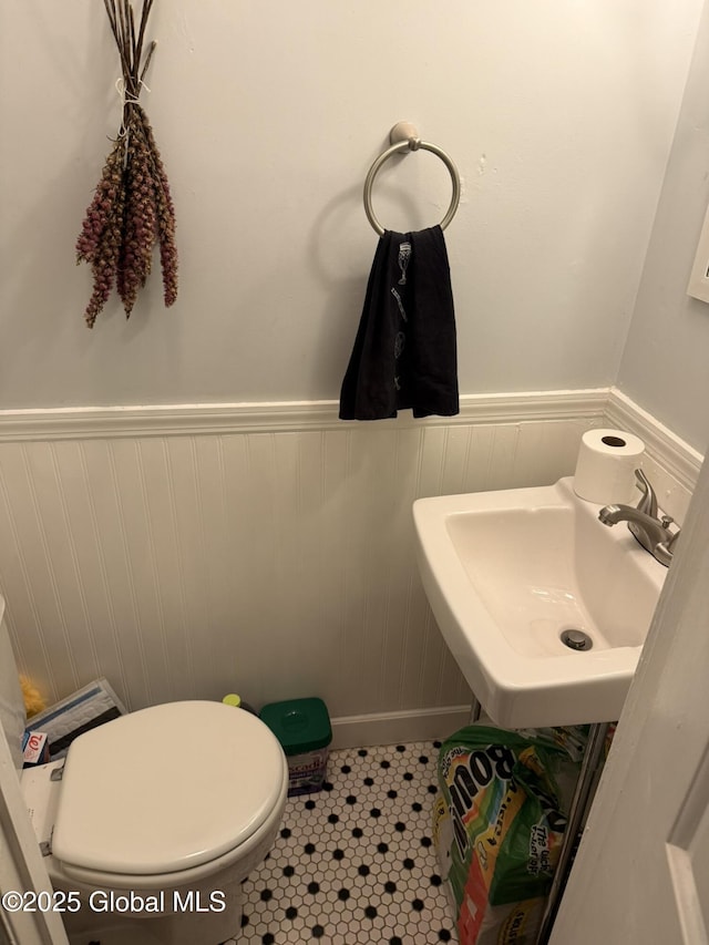 bathroom featuring toilet, tile patterned flooring, and sink