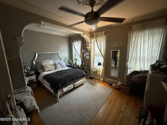 bedroom featuring ceiling fan, hardwood / wood-style floors, and crown molding