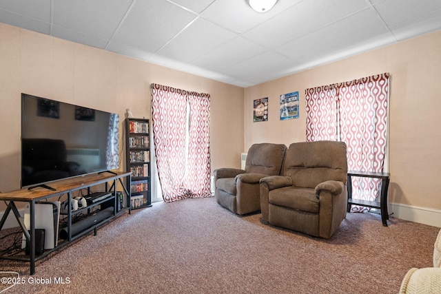 living room with a drop ceiling and carpet flooring