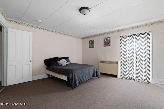 bedroom with radiator, carpet floors, and a drop ceiling