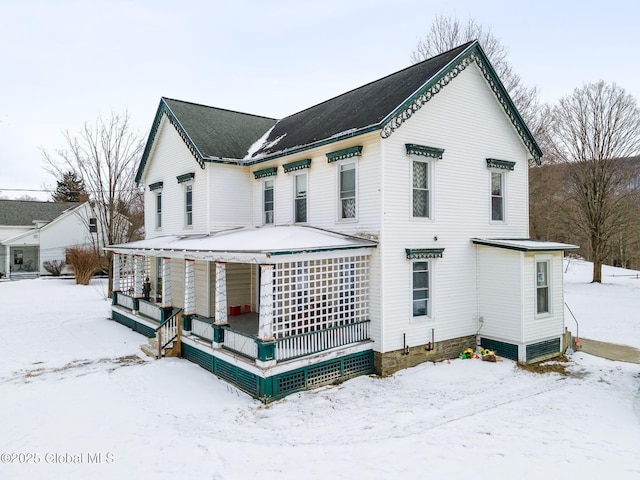 snow covered property with a porch