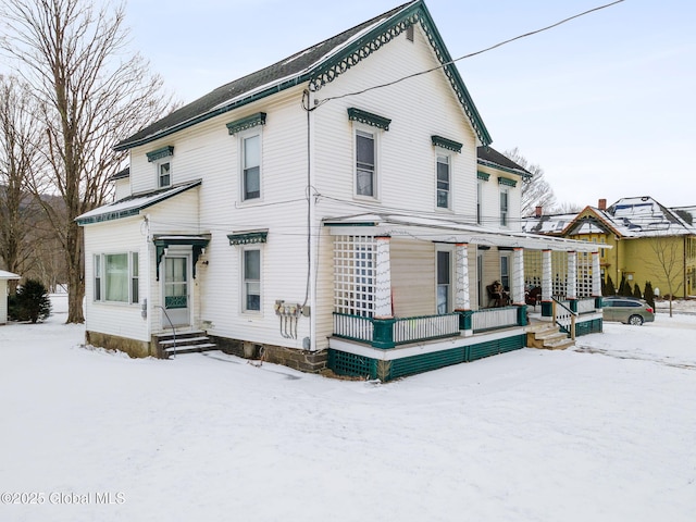 snow covered house featuring covered porch