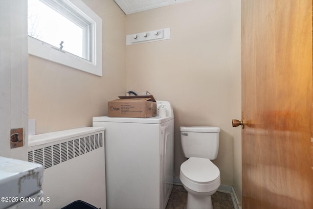 bathroom with toilet, radiator, and washer / dryer