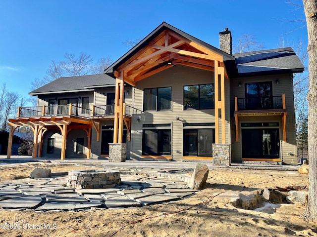 rear view of property with a patio area, a chimney, and a balcony