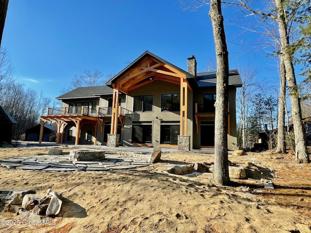 back of house with a chimney and a wooden deck