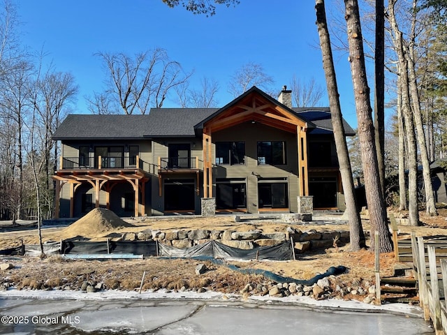 view of front of house with a chimney and a balcony