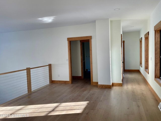 unfurnished room featuring baseboards and light wood-style floors