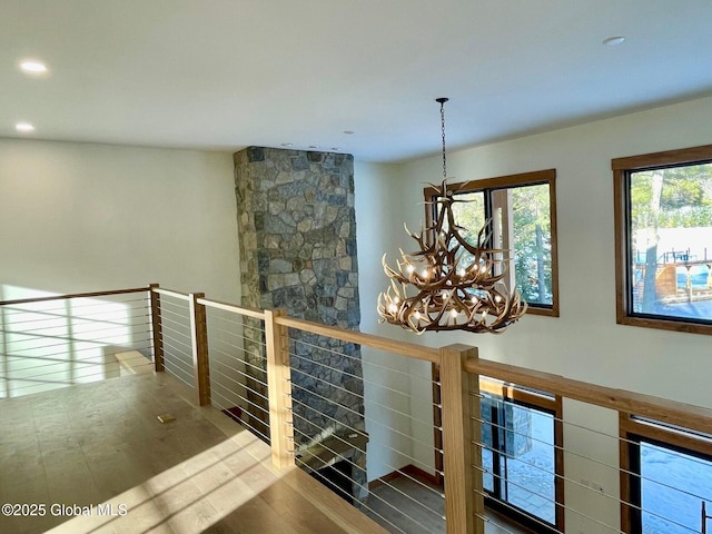 corridor with a chandelier, recessed lighting, an upstairs landing, and wood finished floors