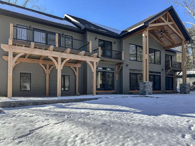 view of front of house with a ceiling fan and a balcony