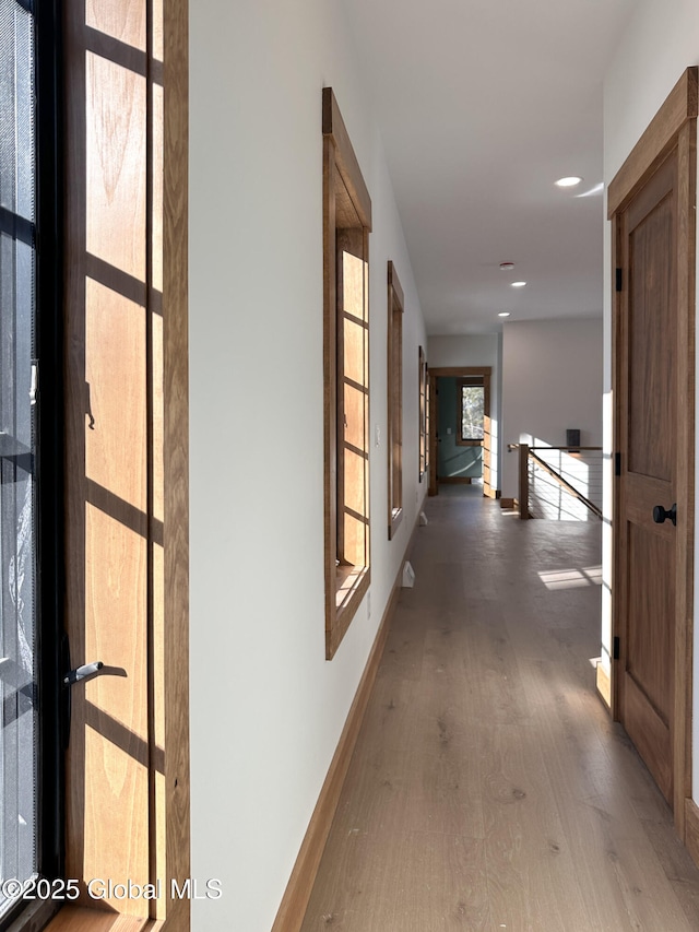 hallway featuring baseboards and wood finished floors