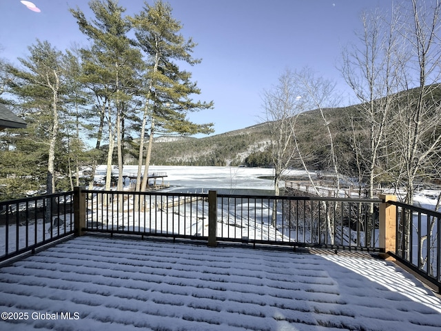 snow covered deck with a mountain view