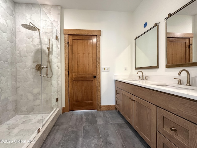 bathroom featuring a stall shower, a sink, baseboards, and double vanity