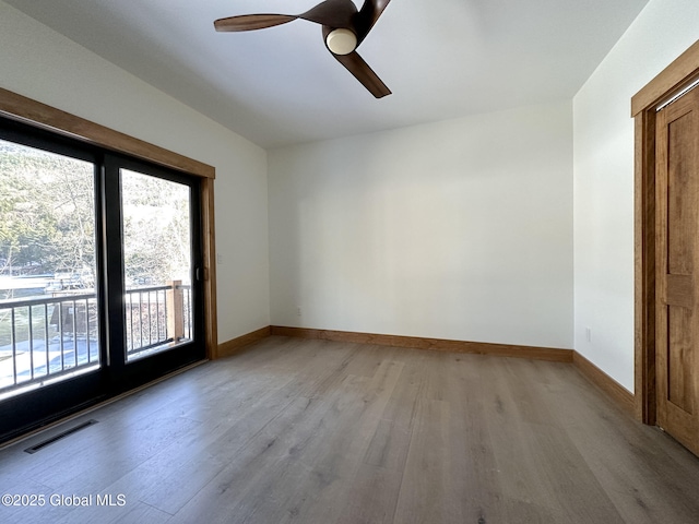 spare room with light wood-style floors, baseboards, visible vents, and ceiling fan