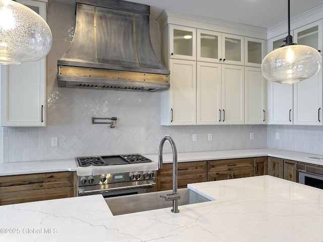 kitchen featuring glass insert cabinets, high end stainless steel range oven, custom exhaust hood, and light stone countertops