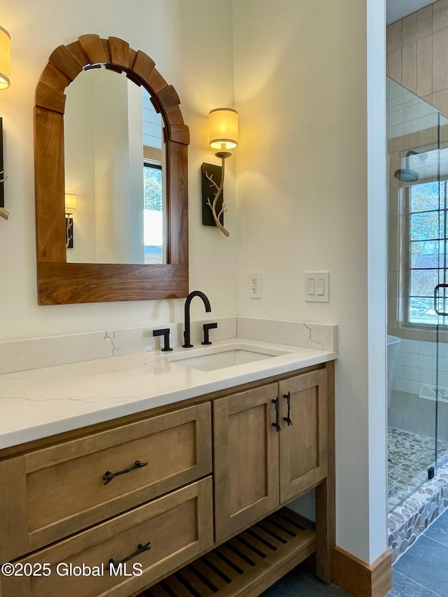 full bathroom with a shower stall, baseboards, a wealth of natural light, and vanity