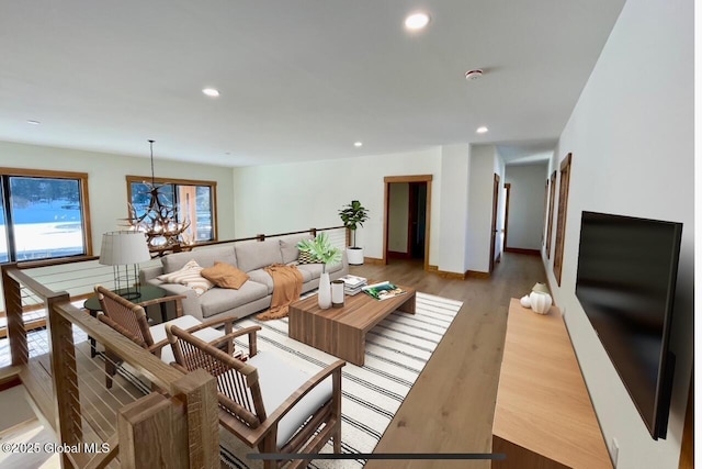 living area with a notable chandelier, baseboards, wood finished floors, and recessed lighting