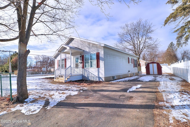 view of front of property featuring a storage shed