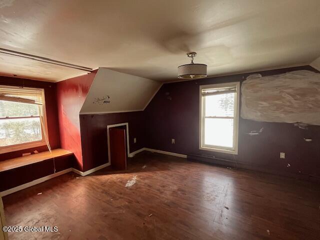 bonus room with dark hardwood / wood-style flooring and vaulted ceiling