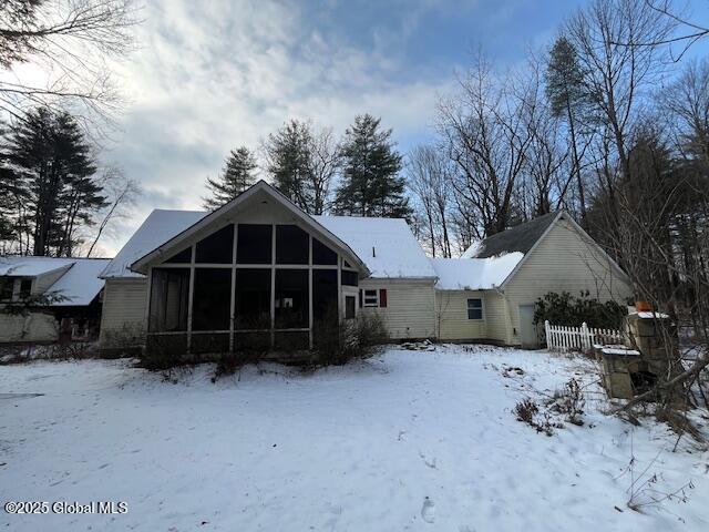 snow covered house with a sunroom