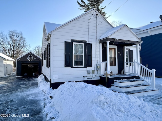 bungalow-style home featuring a garage and an outbuilding