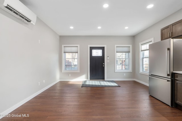 foyer entrance with dark wood-type flooring and a wall mounted AC