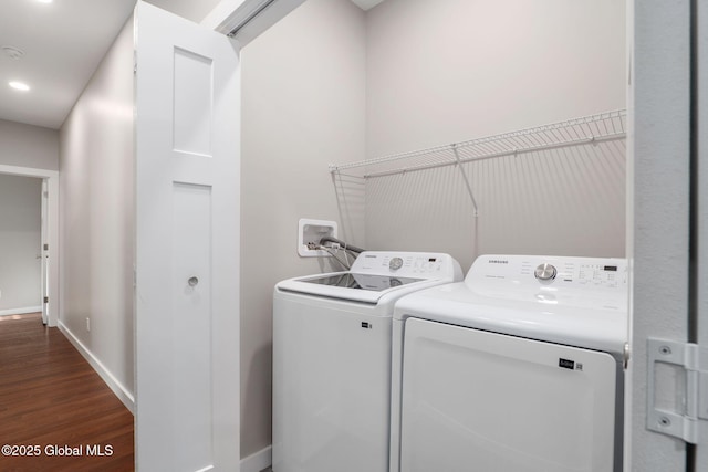 laundry area with dark wood-type flooring and separate washer and dryer