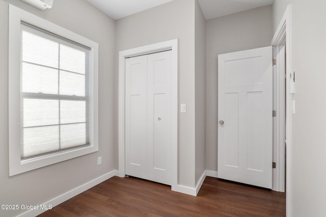 interior space with a wall mounted AC and dark hardwood / wood-style floors